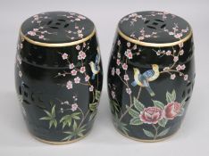 A PAIR OF CHINESE STYLE PORCELAIN BARREL SEATS, black ground painted with birds. 18ins high.