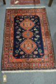 A PERSIAN DESIGN RUG, red and blue ground with stylised animal and bird motifs. 4' 0