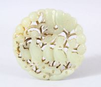 A CHINESE CARVED JADE DISK / PENDANT - Carved with birds aside foliage. 6.5cm.