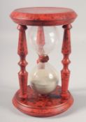 A TORTOISESHELL PAINTED SAND TIMER. 10ins high.