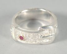 A SILVER OPAL AND RUBY BUCKLE RING.