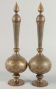 A GOOD PAIR OF ISLAMIC IRON LIDDED BOTTLES, with gilt decoration and panels of calligraphy, 41cm