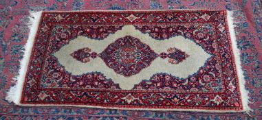 A SMALL INDIAN RUG, crream ground with floral decoration. 4'4