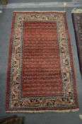 A SMALL PERSIAN RUG, red ground with stylised Boteh decoration. 4'2