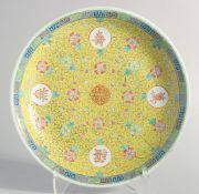A LARGE CHINESE YELLOW GROUND FAMILLE ROSE PORCELAIN DISH, painted with longevity symbol and