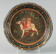 A LARGE INDIAN KASHMIR LACQUERED DISH, the centre painted with a male and female riding a camel,