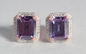 A PAIR OF ROSE GOLD ON SILVER FAUX AMETHYST EAR STUDS.