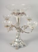 AN ORNATE SILVER-PLATED CENTREPIECE, with a central cut glass bowl, the four scrolling arms, each