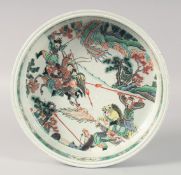 A CHINESE FAMILLE VERTE PORCELAIN BOWL, the interior painted with warriors on horseback, the base