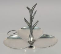 A SILVER COLOUR SHAPED RING STAND.