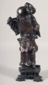 A CHINESE CARVED ROOTWOOD FIGURE of an immortal, mounted to a hardwood base, 33.5cm high.