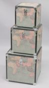 A GRADUATED SET OF THREE TRUNKS, the exteriors decorated with maps. Largest trunk: 1ft 6ins square.