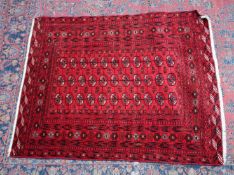 A PERSIAN BOKHARA RUG, red ground with three rows of eleven gulls. 5'4