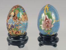 TWO CLOISONNE EGGS on a stand.