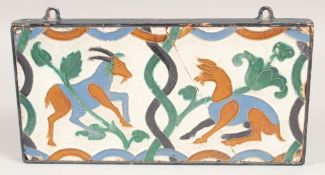 A RARE 17TH CENTURY ISLAMIC SPANISH GLAZED TILE, inset with an old metal frame, 28.5cm x 14.5cm