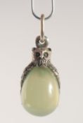 A SILVER AND JADE EGG SHAPED PENDANT, modelled as an owl. 2.5cm high
