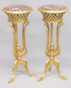 A PAIR OF GILTWOOD AND ROUGE MARBLE CIRCULAR PEDESTAL STANDS, with curving legs. 3ft 2ins high x 1ft