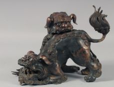 A CHINESE CAST BRONZED CENSOR modelled as two playful foo dogs. 11ins high.