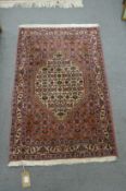 A GOOD SMALL PERSIAN DESIGN RUG, rust ground with stylised floral decoration. 3'5