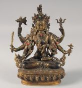 A TIBETAN BRONZE MULTI-ARMED DEITY inset with coral and turquoise stones. 8.5ins high.