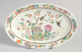 A CHINESE FAMILLE ROSE OVAL PORCELAIN DISH, painted with birds and native flora, six-character
