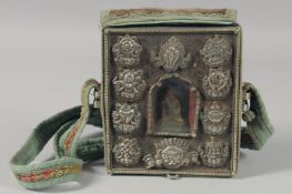 A TIBETAN TRAVELLING SHRINE, in an embroidered cloth case. 6ins x 5.25ins.
