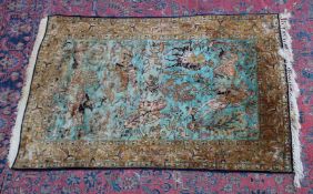 A PERSIAN SILK HUNTING CARPET, pale turquoise ground with figures on horseback hunting various