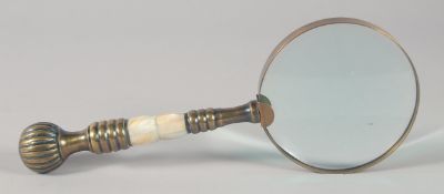 A MAGNIFYING GLASS with brass and mother of pearl handle.