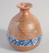 A SMALL JAPANESE POTTERY BOTTLE, with glazed decorative blue and white band, signed to base, 12cm