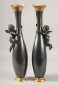 A GOOD PAIR OF 19TH CENTURY BRONZE AND GILT VASES with cupids. 16ins high.