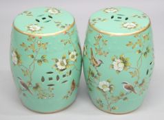 A PAIR OF CHINESE STYLE PORCELAIN BARREL SEATS, green ground painted with birds. 18ins high.