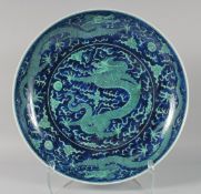 A LARGE CHINESE PORCELAIN DRAGON CHARGER, painted with numerous dragons chasing the flaming pearl of