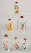 A COLLECTION OF SIX REVERSE-PAINTED SNUFF BOTTLES AND STOPPERS.