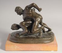 OLIVER TUPTON A BRONZE SCULPTURE, TWO NUDE MALE WRESTLERS. Signed, 9ins long on a marble base.
