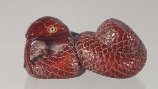 A CARVED WOOD NETSUKE modelled as a snake. 5.5cm long.