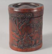 A CHINESE BAMBOO LIDDED BRUSH POT, with carved landscape decoration and characters, 13.5cm high.