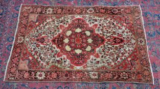 A PERSIAN DESIGN RUG, cream ground with stylised pink floral decoration. 4'11