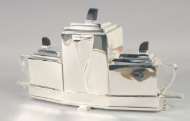 AN ART DECO STYLE PLATED THREE PIECE TEA SERVICE ON STAND. 15.5