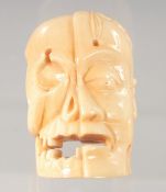 A JAPANESE CARVED BONE NETSUKE, modelled as a head. 5.5ins long.