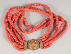 A FIVE STRAND CORAL BEAD NECKLACE WITH 18CT GOLD CLASP. 40cm long