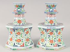 A PAIR OF CHINESE WUCAI PORCELAIN OCTAGONAL CANDLESTICKS, painted with panels of floral motifs, 27.