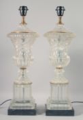 A PAIR OF MOULDED GLASS URN SHAPED LAMPS on marble bases. 23ins high.