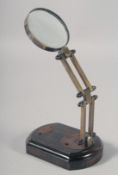 A SMALL BRASS MAGNIFYING GLASS on a stand.