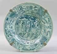 A CHINESE BLUE AND WHITE PORCELAIN DISH, painted with panels figures and objects. 29.5cm diameter.