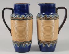 A PAIR OF ROYAL DOULTON STONEWARE JUGS with blue bands. 8ins high.