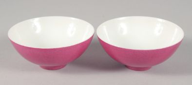 A PAIR OF CHINESE PINK GLAZE PORCELAIN TEACUPS, each with mark to base, 8cm diameter.