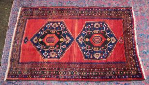 A GOOD SMALL PERSIAN CARPET, red ground with two large central medallions. 7'2