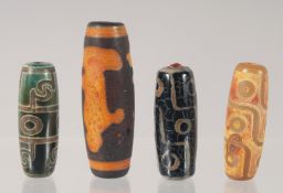 FOUR CHINESE AGATE DZI BEADS Largest, 4cm long.