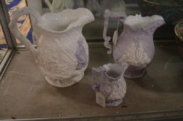 Three relief moulded jugs with lilac tinted decoration.