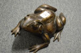 A cast bronze model of a frog.